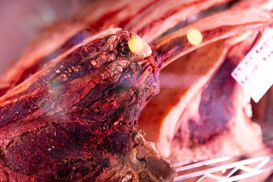 Slices of dried beef meat along with types of sausages in dry ading cabinet. Dry-aged cuts of raw meat. Food manufactoring.