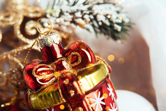 Close-up of Christmas tree decorations. New Year's toy in the form of a red gift. Holiday and New Year concept. Idea for a card or poster.
