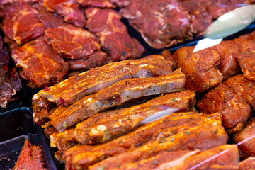 Showcase window of diverse meat production in butchers shop. Meats sale department in the hypermarket.