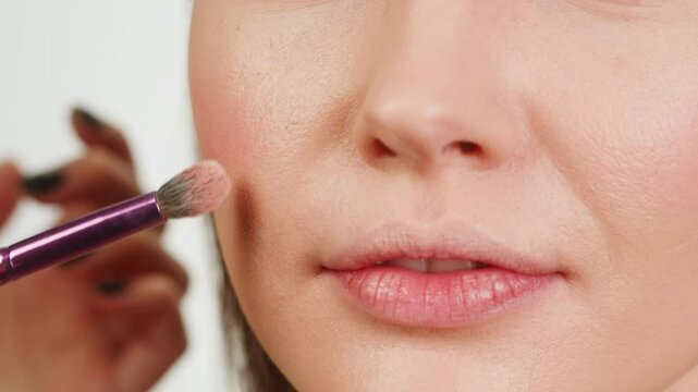 Beauty shot of woman makeup artist applying foundation bb cream on previously applied moisturizing young woman face close-up. Concept of skincare, cosmetics, make up, beauty