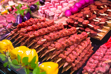 Turkish kebab on skewers with spices on showcase in butchers shop. Turkish cuisine on tray for...