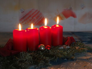 Weihnachtliche Dekoration mit vier roten brennenden Kerzen 