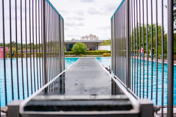 Wet Dive Board View at Public Outdoor Swimming Pool with Railing