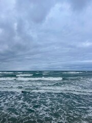 Cloudy seascape, seashore waves, natural sea horizon, cloudy sky