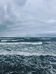Cloudy seascape, seashore waves, natural sea horizon, cloudy sky