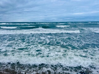 Cloudy seascape, seashore waves, natural sea horizon, cloudy sky