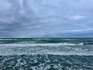 Cloudy seascape, seashore waves, natural sea horizon, cloudy sky