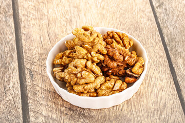 Cracked unshelled walnut in the bowl