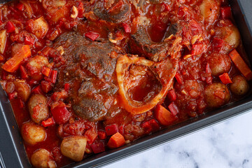 ossobuco stew with vegetables, knuckle on the bone with new potatoes, in tomato sauce,homemade, top view, no people,