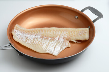 fresh haddock fillet in a teflon frying pan