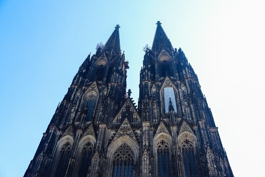Exterior view of a Cathedral in Cologne with its two towers and Gothic architecture.