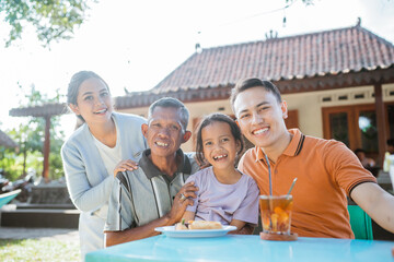 happy asian family having meal in outdoor restaurant
