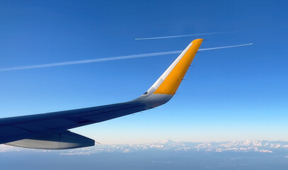 View from plane window on wing, two white airplane traces against the sky