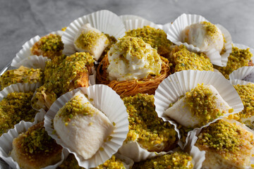 A closeup view of a catering tray of a mix of kunafa, halawet el jibn, shaabiyat, aish el saraya.
