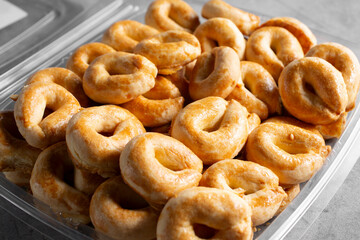 A closeup view of a plastic container of aniseed cookies.
