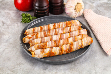 Raw sausages wrapped in bacon