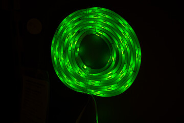 A coiled green LED strip light, showcasing modern, energy-efficient lighting solutions. Ideal for concepts of eco-friendly illumination, smart home decor, or versatile business lighting