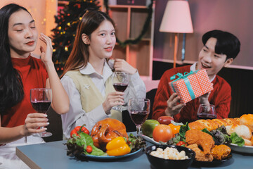 Friends opening Christmas gifts in living room