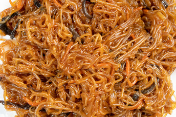Funchoza, Chinese noodles with mushrooms and vegetables on a wooden background. Food concept. Chinese food.