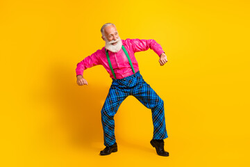 Full body photo of retired man dancing good mood dressed pink shirt vintage plaid pants fancy clothes isolated on yellow color background