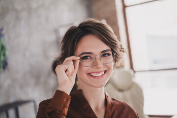 Photo of pretty young girl touch specs smile wear brown silk shirt coworking successful nice light office