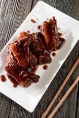 Pork ribs in honey soy sauce on a wooden background. Food concept. Chinese food.
