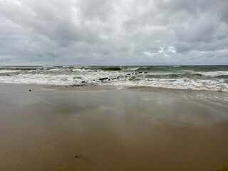 cloudy seascape, sandy shore, empty wild beach, clouds and waves