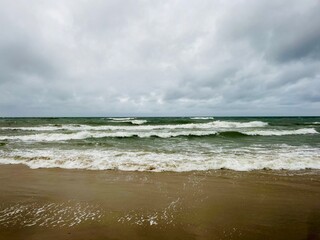 cloudy seascape, sandy shore, empty wild beach, clouds and waves