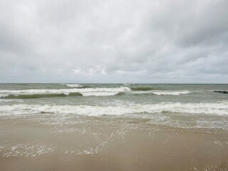 cloudy seascape, sandy shore, empty wild beach, clouds and waves