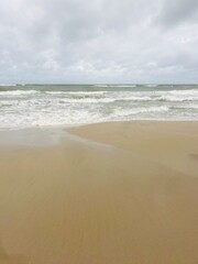 cloudy seascape, sandy shore, empty wild beach, clouds and waves