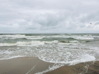 cloudy seascape, sandy shore, empty wild beach, clouds and waves