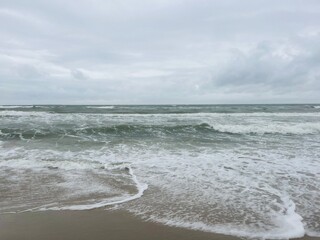 cloudy seascape, sandy shore, empty wild beach, clouds and waves