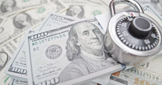 Financial security, wealth protection, confidentiality, and safeguarding investment : Stacks of US dollar 100 bills with a combination lock, depicting wealth management, savings, protection of assets.
