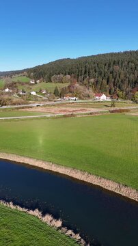 Beautiful drone footage showcasing the picturesque town of Morteau in France, nestled in a lush green valley with a winding river. This serene countryside scene is perfect for travel content,promotion