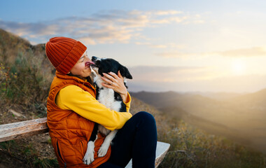 Happy woman embracing her dog at sunset outdoors. Life with dog. 