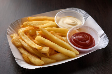Eine Portion Pommes Frites mit Mayonnaise und Ketchup auf einem Pappteller - Generated Image