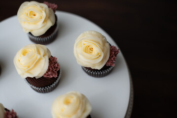 chocolate cupcakes on cake stand with buttercream roses and chocolate ganache