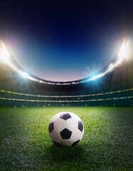Flutlichtstadion mit Fußball auf dem Rasen