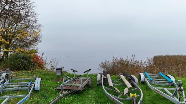 Stunning drone footage capturing the tranquil beauty of a lake with crystal-clear water and a rocky shoreline surrounded by autumn foliage. Perfect for use in nature documentaries, travel content