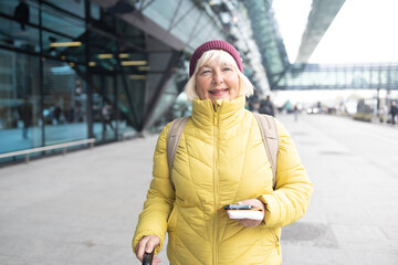 stylish pretty 50s woman traveling with suitcase in Europe in trend autumn outfit street style. High quality photo