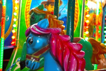 painted horses on merry-go-round carousel at carnival amusement park © Aiden