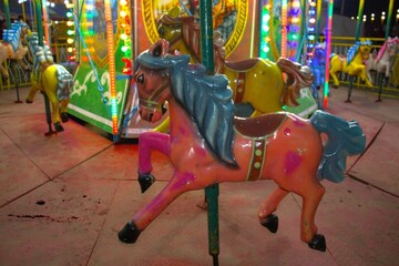 painted horses on merry-go-round carousel at carnival amusement park © Aiden