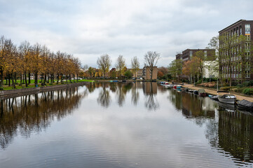 Houses and autumn color trees reflecting in the Admiral's canal in Amsterdam, The Netherlands