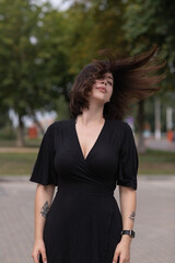 Portrait of a young beautiful dark-haired girl in an urban environment in summer.