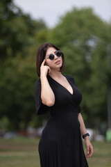 Portrait of a young beautiful dark-haired girl in an urban environment in summer.