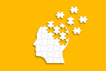 Dementia and parkinson's disease. Head and brain diseases concept. Human head shaped puzzle on yellow background.	