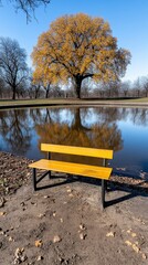 Obraz premium Serene Autumn Park Yellow Bench by Pond Golden Tree Reflection