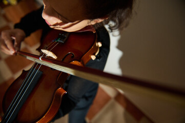 Focused violinist playing in a warmly lit room