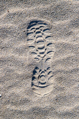 Close-up of a shoe print on the sand