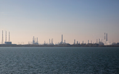 Naklejka premium Landscape with the silhouette of a refinery seen from a distance